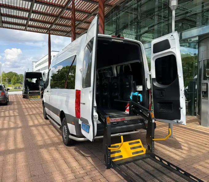 Rolstoelbus met uitgeklapte lift bij een zorglocatie